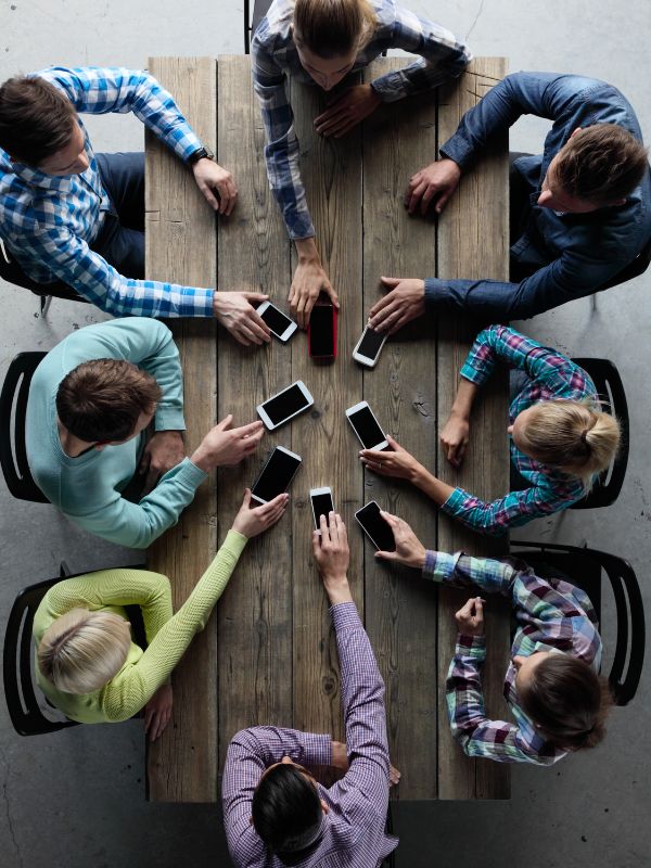 a wooden table with 8 people sitting around in a community meeting